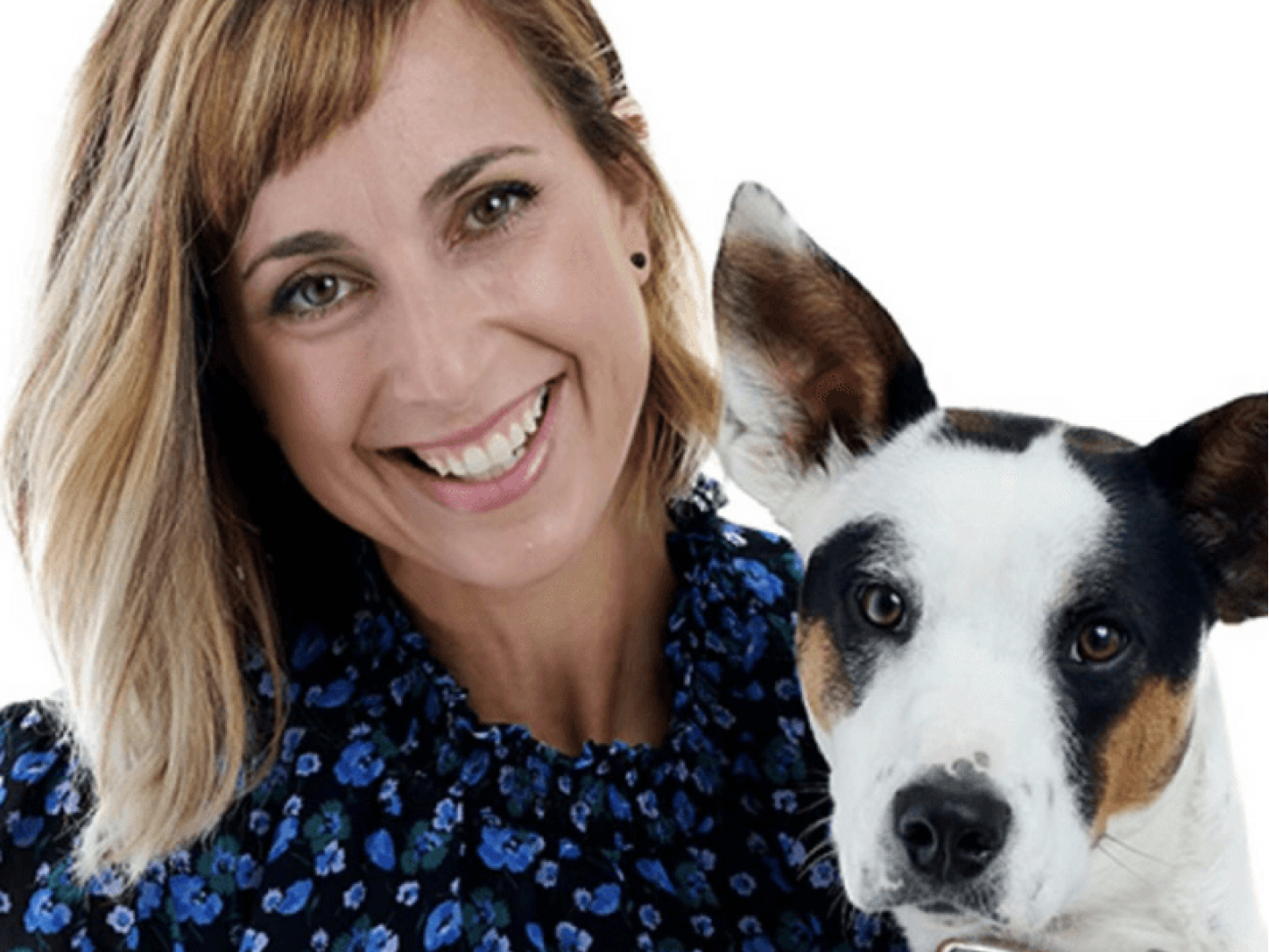 This image depicts a woman beside a white dog smiling